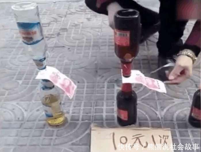 稳稳地放在地上,而顶上则嘴对嘴倒扣着一个空的酒瓶,两个瓶口之间夹着
