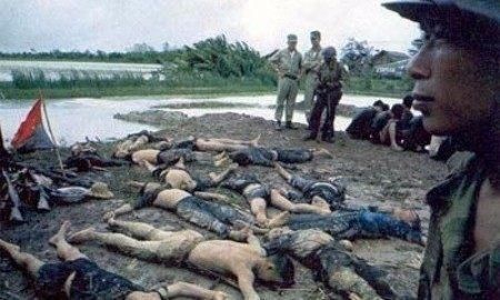 一个越南士兵在满地尸首前.