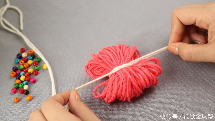 第二步:将缠绕好的毛线用一根毛线(长一些,够3,4个毛球固定)打结固定