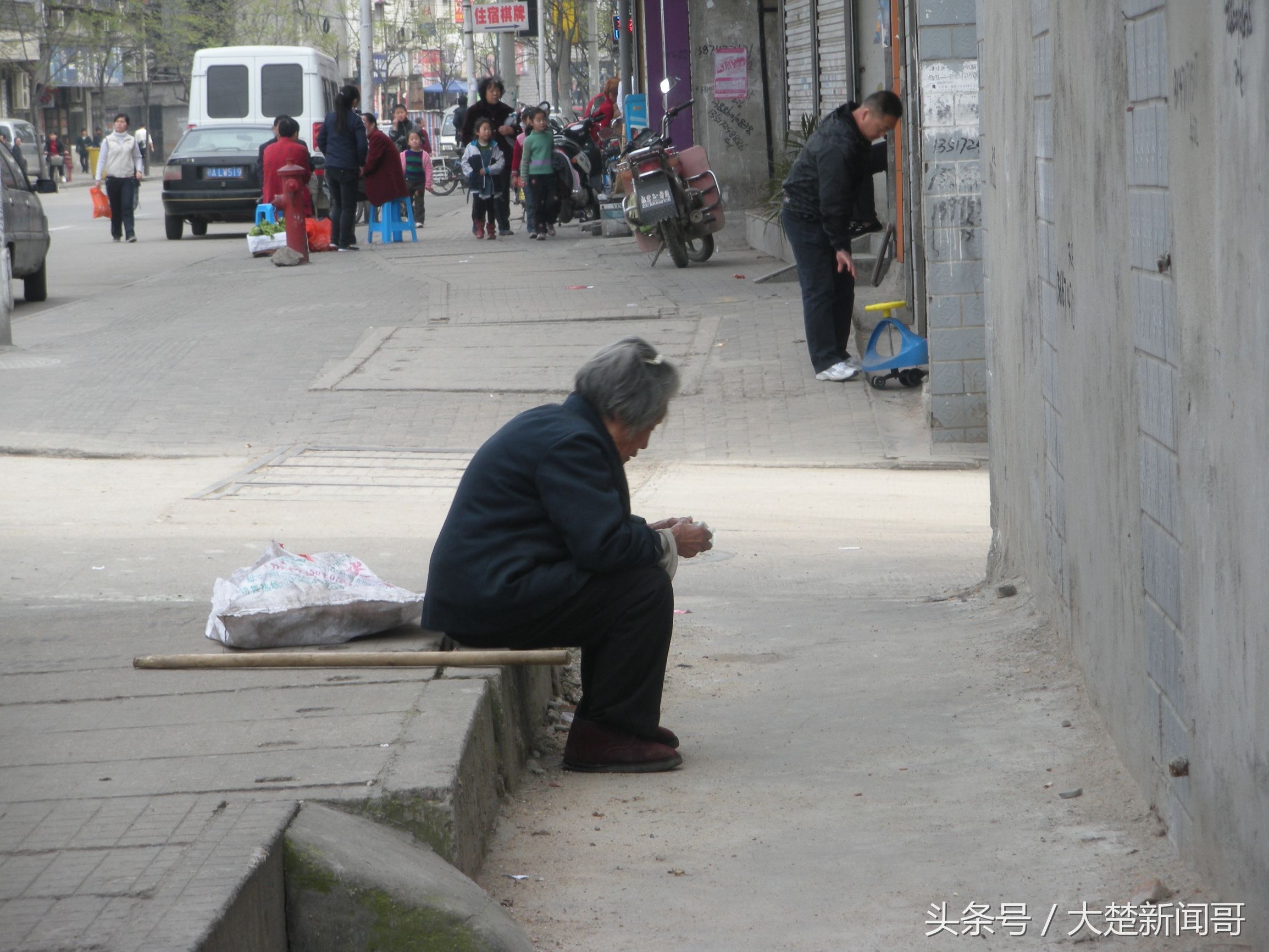 2010年4月3日,汉口,拾荒走累了坐在路边休息的老人,70岁.