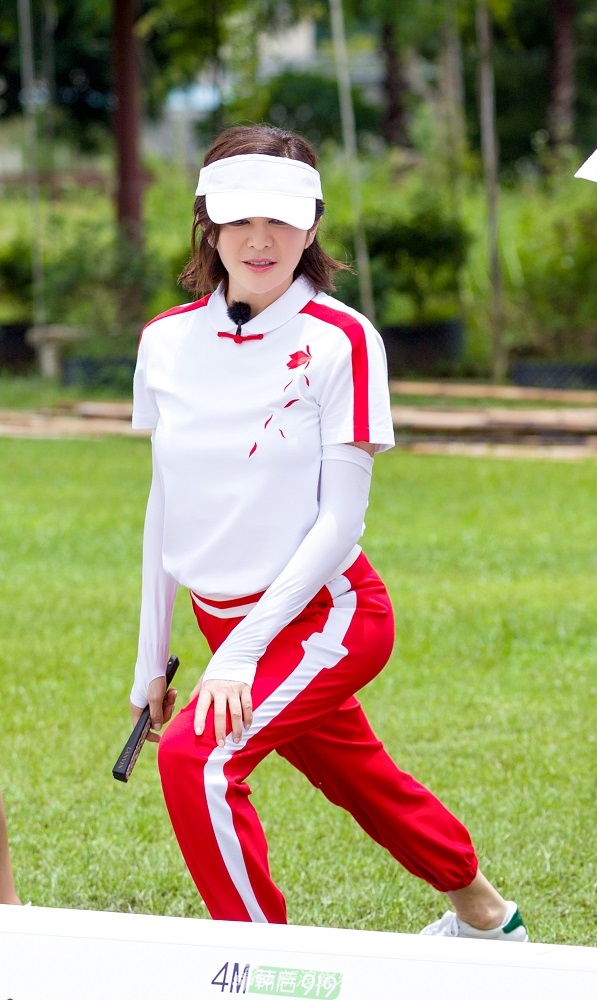 在《我们来了》节目剧照中,关之琳背上降落伞挑战跳远,运动活力突破