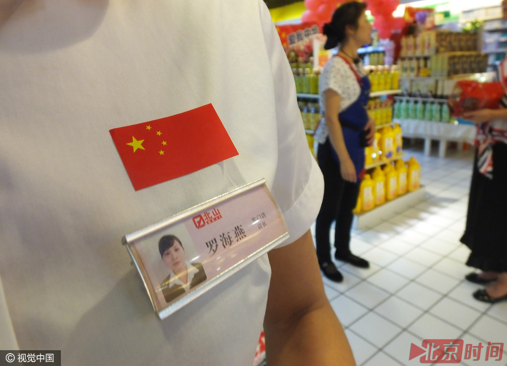 超市营业员脸贴国旗 柜台挂标语欢度国庆节