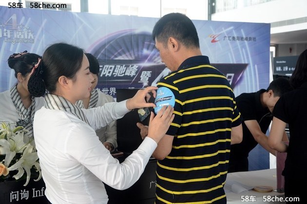 销售顾问细心为嘉宾贴上活动臂贴