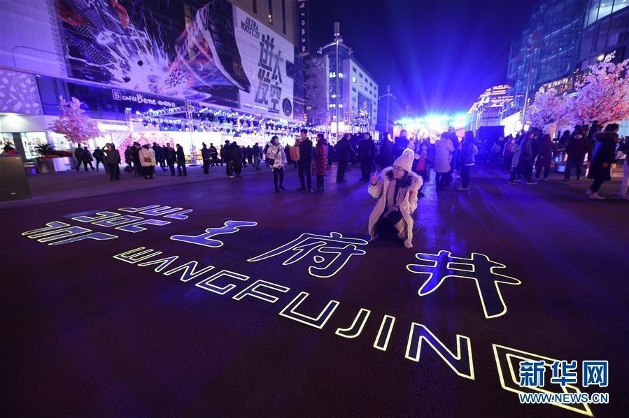 12月20日，游客在新开街的王府井步行街北延段拍照留念。新华社记者 鞠焕宗 摄