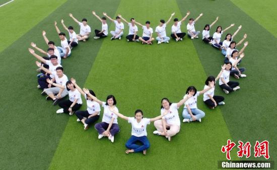 湖南道縣第一中學高三年級學生在校園裡擺出各種姿勢拍攝創意畢業照