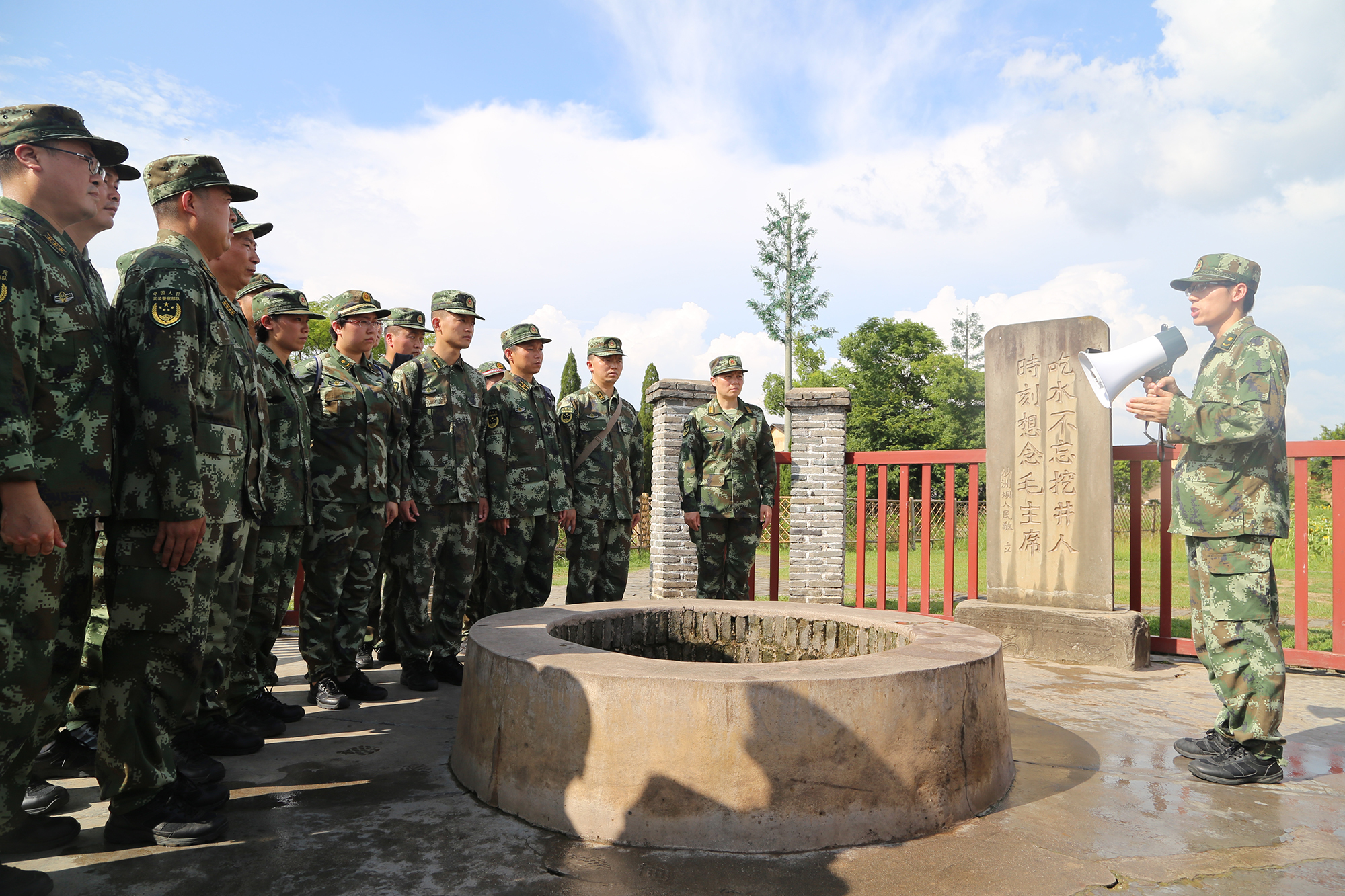 2016年8月10日，武警警官学院组织机关干部到江西瑞金参观见学，这是他们在瑞金沙洲坝红井旁，聆听“吃水不忘挖井人”的故事。