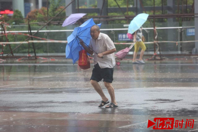 10月21日中午，受台风“海马”影响，深圳风力强劲，雨量增加。图为建设路上的行人只能迎风撑伞，冒着暴风雨前行。