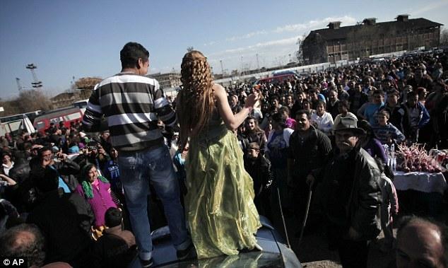 一切商量妥当，二人便算是订婚了。图中这对在集市上相识的情侣开心地跳上车顶，向大家公布自己的喜讯。