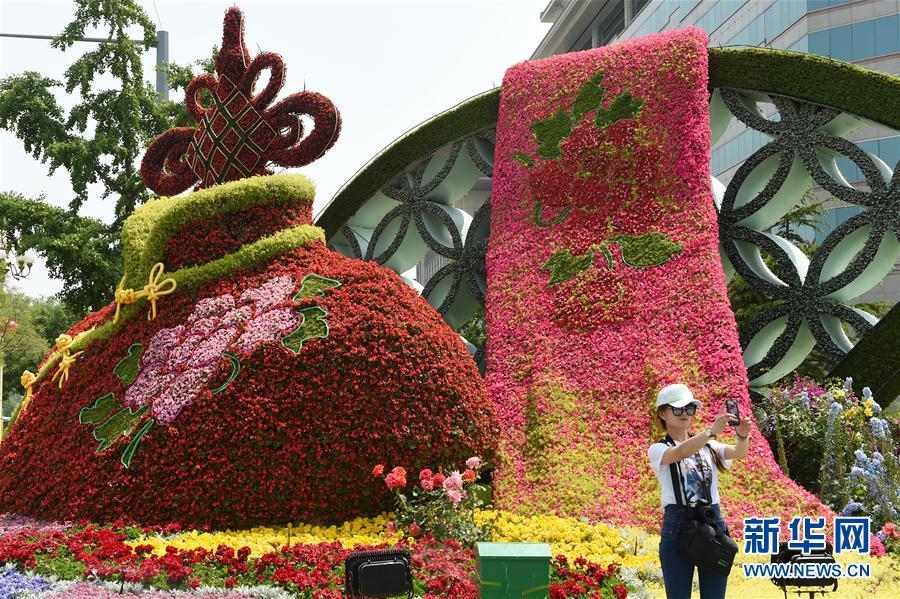 5月9日，市民在为迎接“一带一路”国际合作高峰论坛布置的花坛前留影。