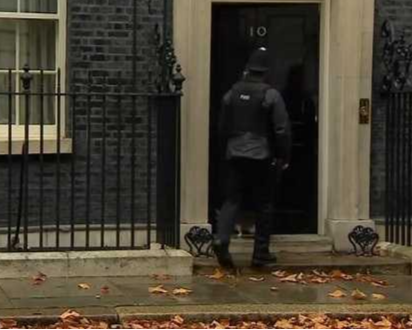 警察犹豫了几秒，随后慢慢走向门口，帮拉里敲门放它进去了。看到这一幕，英国网友都被逗乐了：“警察‘失职’了！他没有守好门！”“可以，这很绅士，这简直是史上‘最英国’的事儿了。”