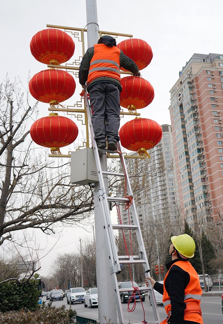 朝阳公园南路,工人为路灯加装红灯笼.