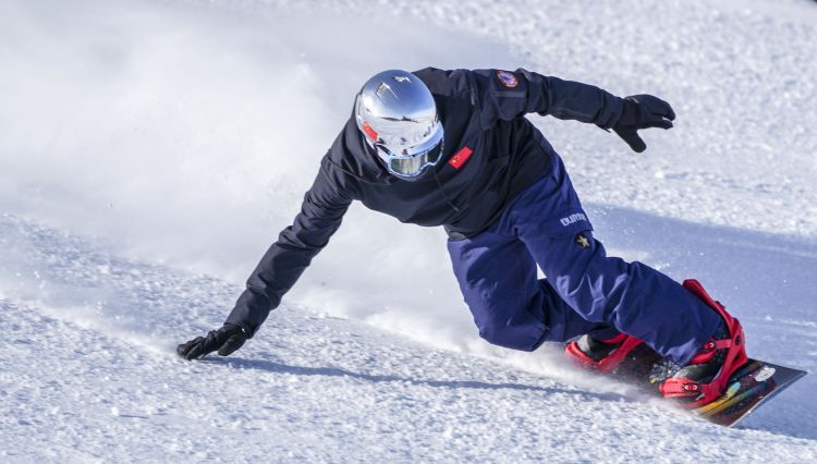一位滑雪爱好者在丝绸之路国际滑雪场一处高级雪道上练习单板滑雪