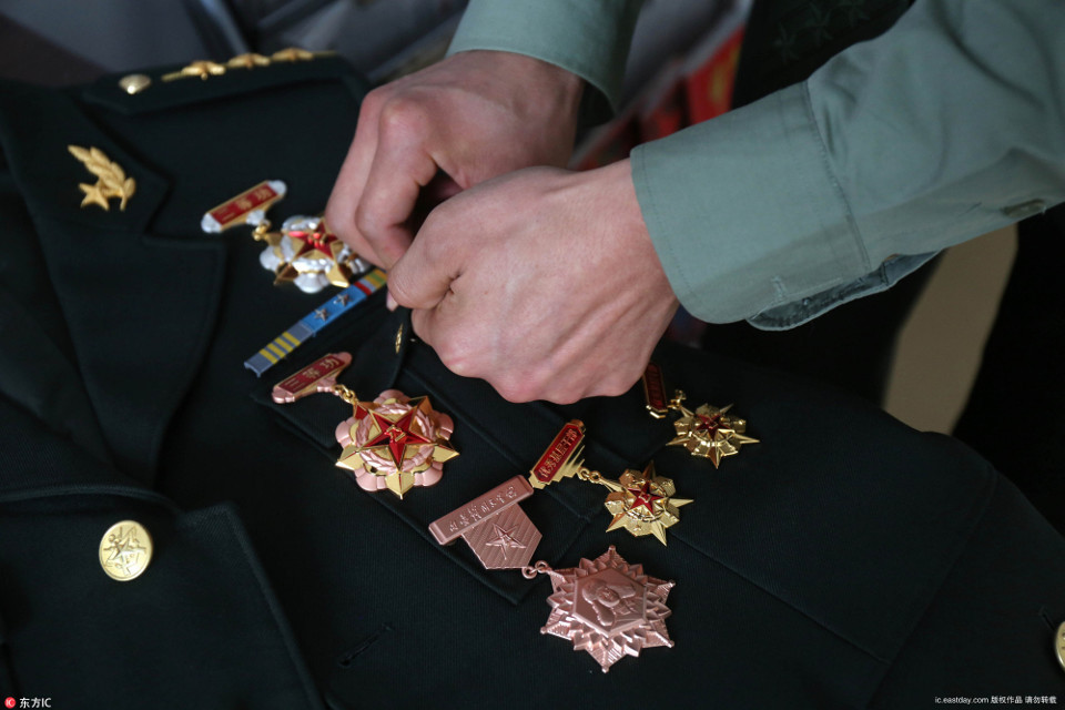 2017年2月1日,黑龙江黑河,张书辉正在给自己的军装佩戴军功章.[!
