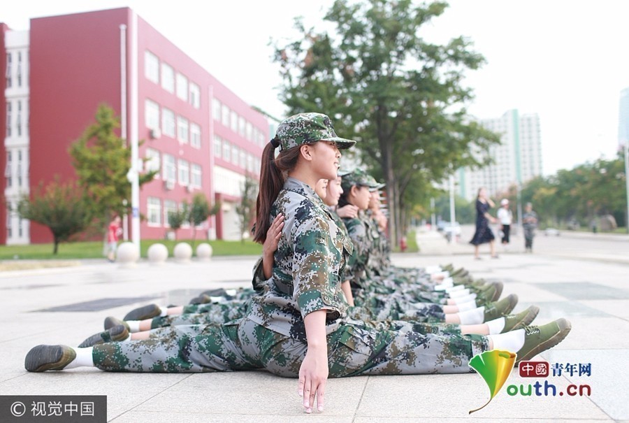 在山东日照,曲阜师范大学内新生进行军训,在休息间隙,舞蹈系的新生大秀一字马、胸倒立等绝技,显出舞蹈新生的深厚功底。（来源：中国青年网）