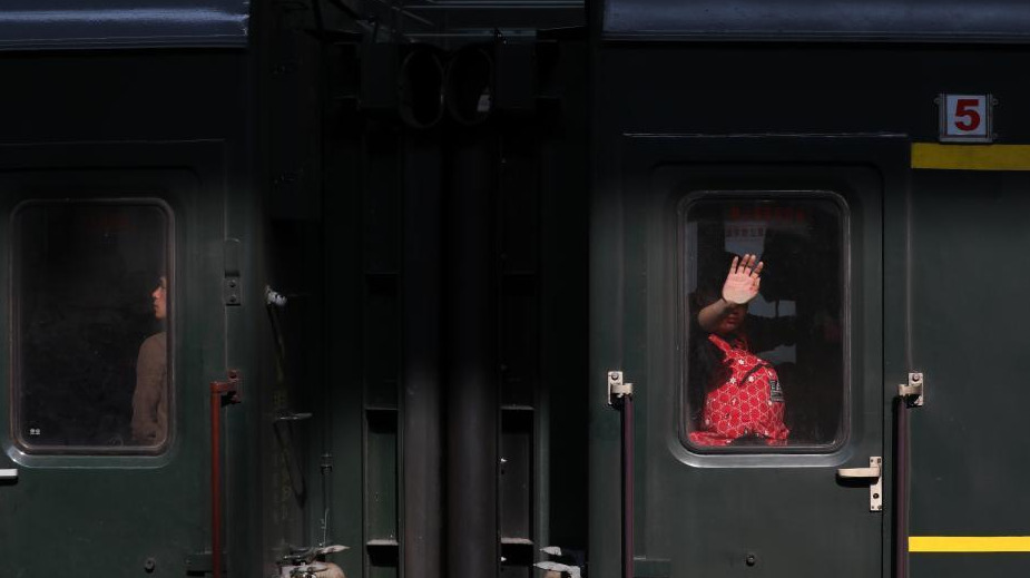 1月24日，透过停靠在南京火车站的列车车窗，车内的乘客或站、或坐、或沉思。随着春节的临近，越来越多的民众带上行李，踏上旅途。