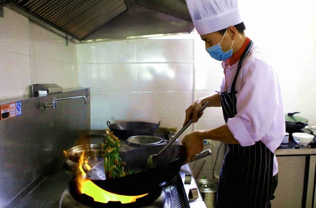 厨师在翻炒菜肴.