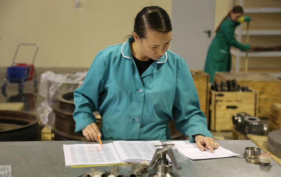 第19维修车间非常安静，女工正在细致地对照工艺流程。