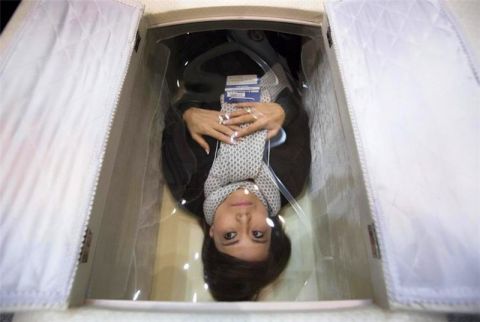尸体旅馆还兼营各种各样的殡葬服务图为一名女性躺在棺材中体验
