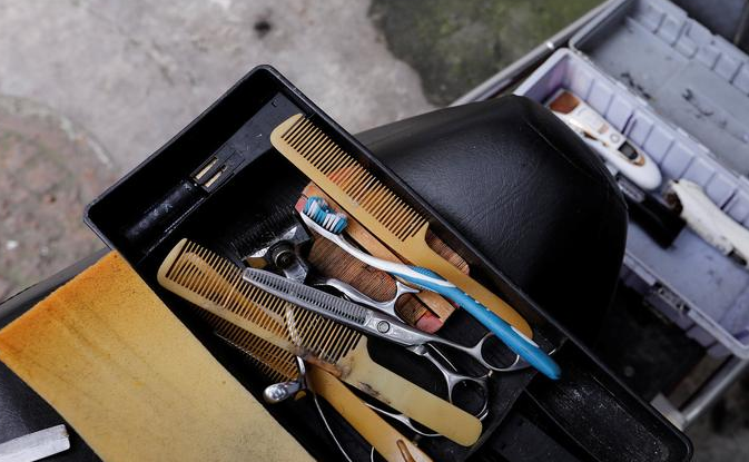 2017年11月18日，四川成都，62岁的街头理发师熊高武为顾客展示刀锋洗眼。熊高武自17岁起就在街头理发。人称“熊三师”的他有三个独门绝技：刀锋洗眼、跳三刀、舒筋。其中最令人称绝的就是刀锋洗眼也就是用锋利的刀片“扫”眼皮，据说只要体验过一次，就不会忘记。