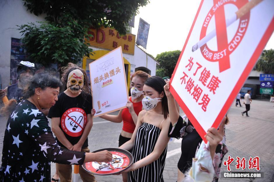 图为工作人员举着灭烟托盘要求游客灭掉手中烟.中新社记者 陈超 摄