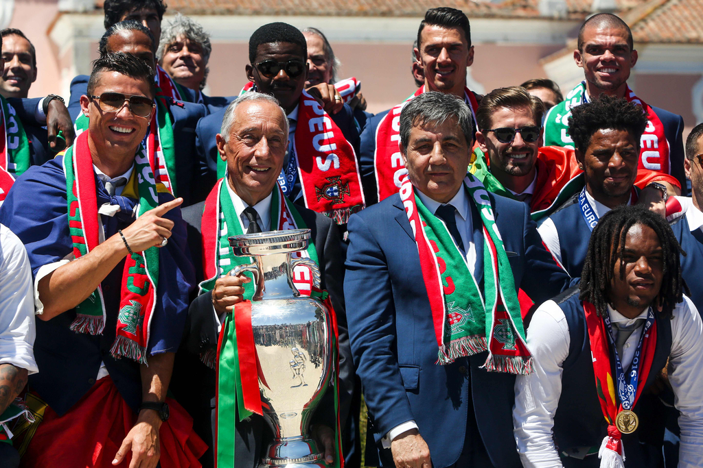 2016年7月11日，葡萄牙里斯本，2016年欧洲杯冠军葡萄牙队回到国内，全体队员和教练乘坐大巴游行并受到葡萄牙总统的接见，全城民众欢欣舞动狂欢庆祝。图为葡萄牙队员捧杯合影