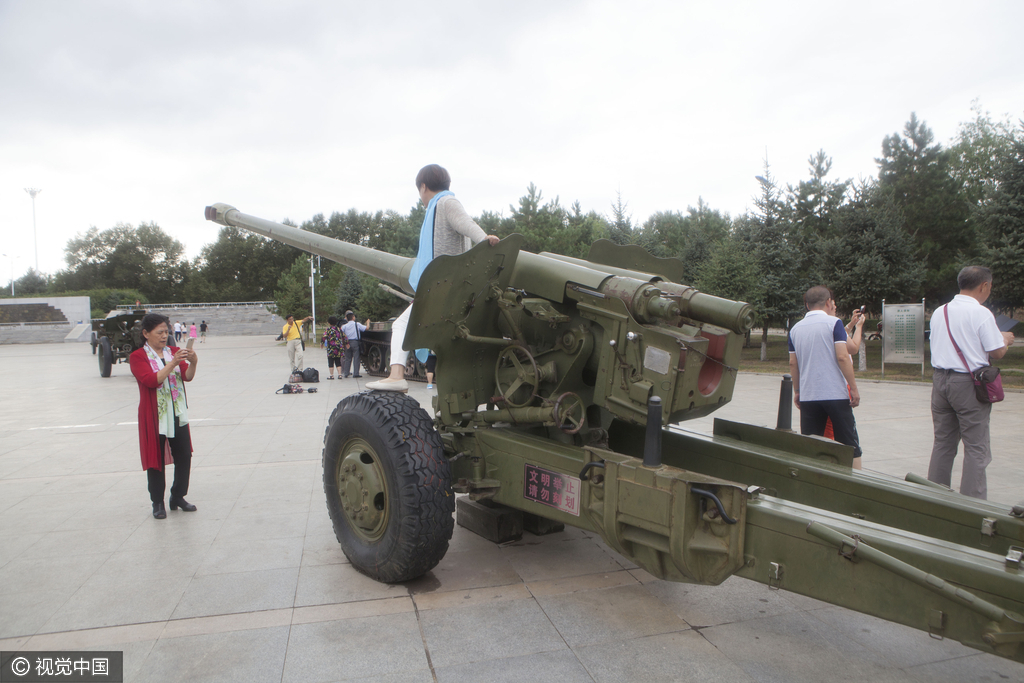 图为市民爬上大炮合影。