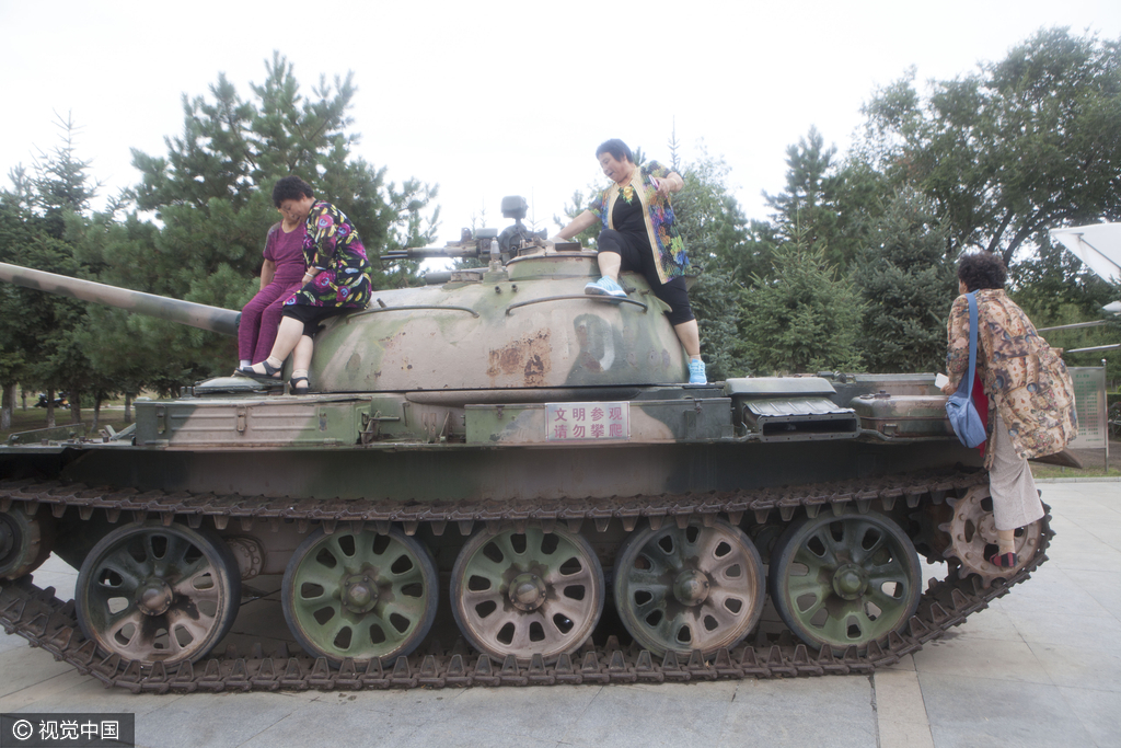 2016年08月10日，黑龙江省齐齐哈尔市，广场现坦克飞机，市民组团攀爬合影。