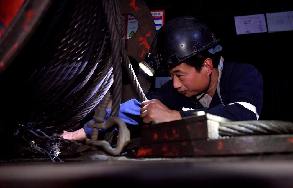 鲁西煤矿3下a01工作面无极绳绞车硐室,采煤工区维修工冯杰正在检修