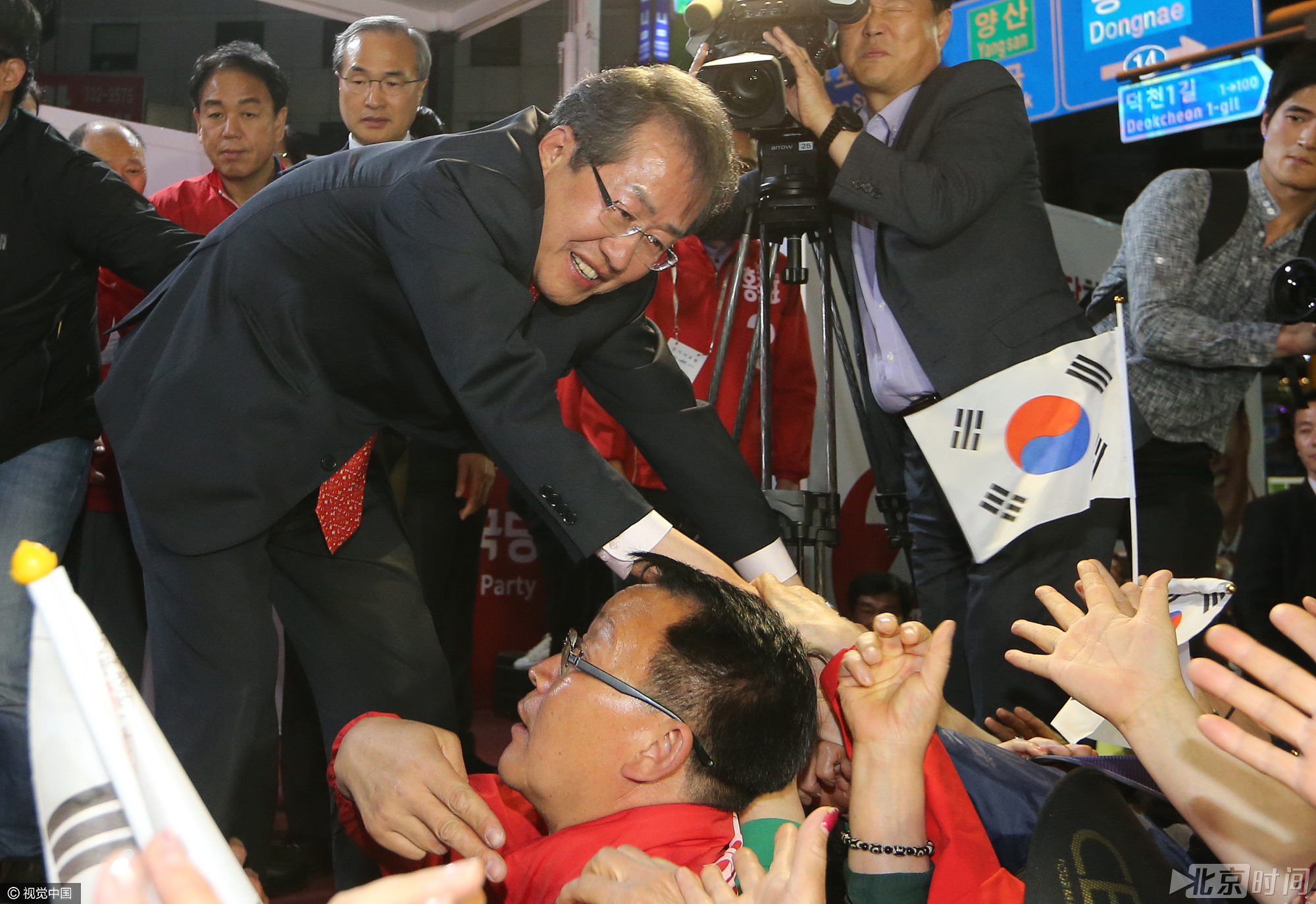 与支持民众握手。