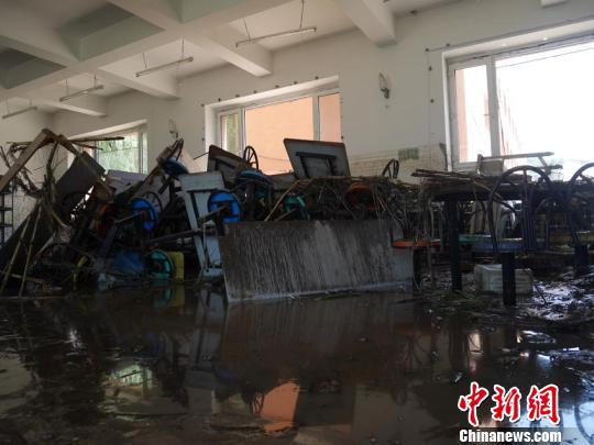在吉林省吉林市丰满区前二道乡金丰村的明智之家孤独症学校，志愿者在清理着走廊内的淤泥。 吉林市13日起突降暴雨，引发洪水灾害，至目前已造成18人死亡，18人失踪。