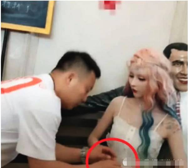 其实是这个样子的, 迪丽拉的旁边有一个黑色的雕像, 然后迪丽拉就非常调皮的也是坐在了这个雕像旁边, 开始模仿其了雕像, 好像很好玩的样子,但是后面的时候就进来了一个男子, 这个男的开始摸雕像。