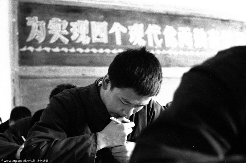 1977年，我国恢复高考。北京考场，标语：为实现四个现代化……。