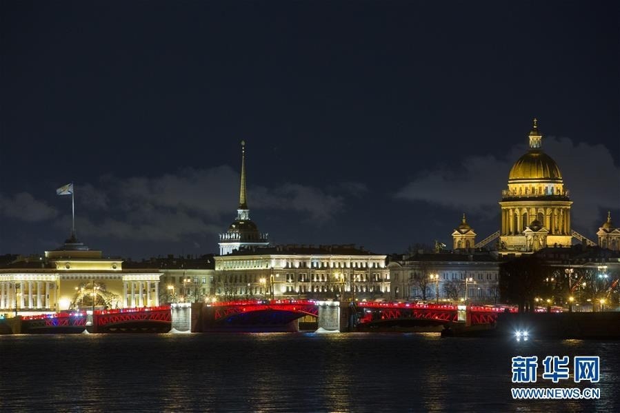 1月24日，俄罗斯圣彼得堡涅瓦河上的宫廷桥点亮红色灯饰，迎接中国农历新年。