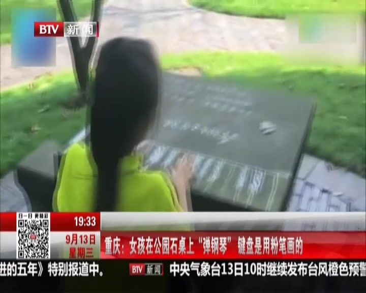 重庆：女孩在公园石桌上“弹钢琴”键盘是用粉笔画的