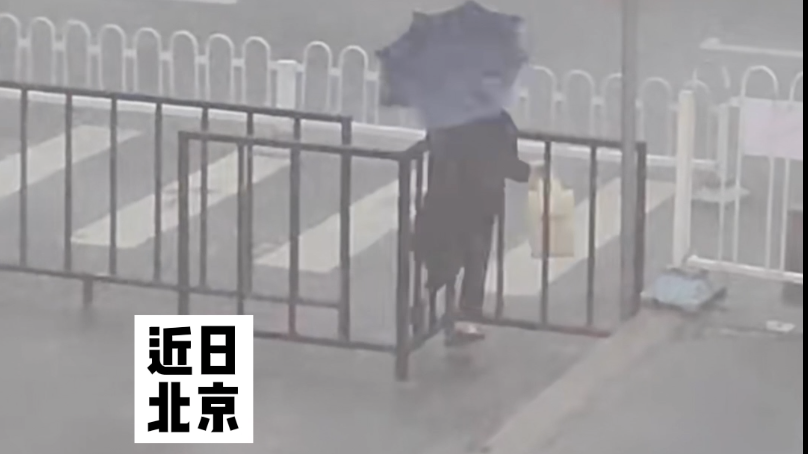 北京大风大雨下,行人的伞明明打了,却好像没打…… 北京大风大雨下,行人的伞明明打了,却好像没打……