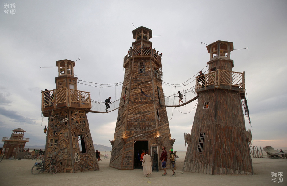 说到火人节，就不得不提黑岩城（Black Rock City）——在短短的八日里，这座城在最荒凉的沙漠里拔地而起又付之一炬。图为人们在艺术装置之间穿梭。