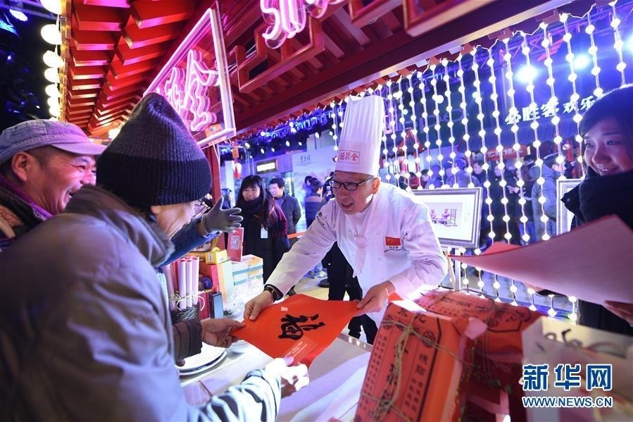 12月20日，“全聚德”的厨师在开街活动上向游客赠送“福”字。新华社记者 鞠焕宗 摄
