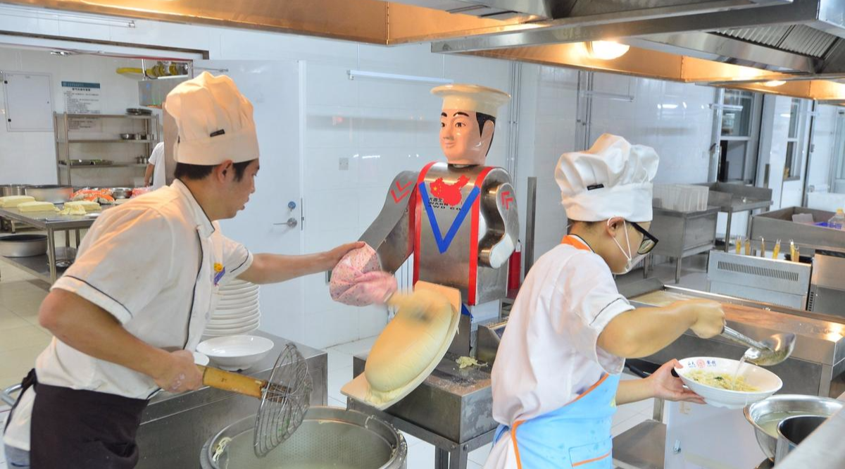 2016年9月17日，山东青岛，山东大学青岛校区迎新生报到第二天，记者在学校餐厅看到，刀削面档口内一个刀削面机器人在制作刀削面，吸引了不少新生和家长尝鲜。