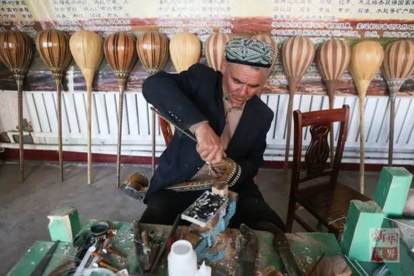 热合曼在家中制作新疆传统乐器都塔尔.