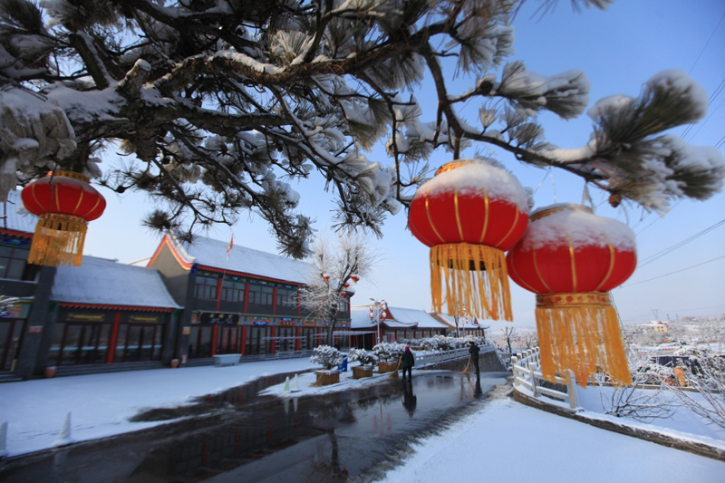 1月31日,在山东临沂红云小镇,工作人员在雪后清扫道路