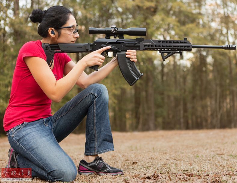 美女手持Saiga-12霰弹枪打靶，配有三角握把和瞄具。