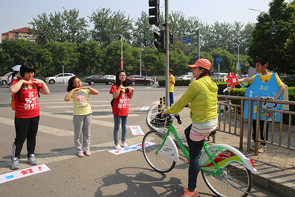 小志愿者用手语操的形式陪伴行人耐心等候红灯