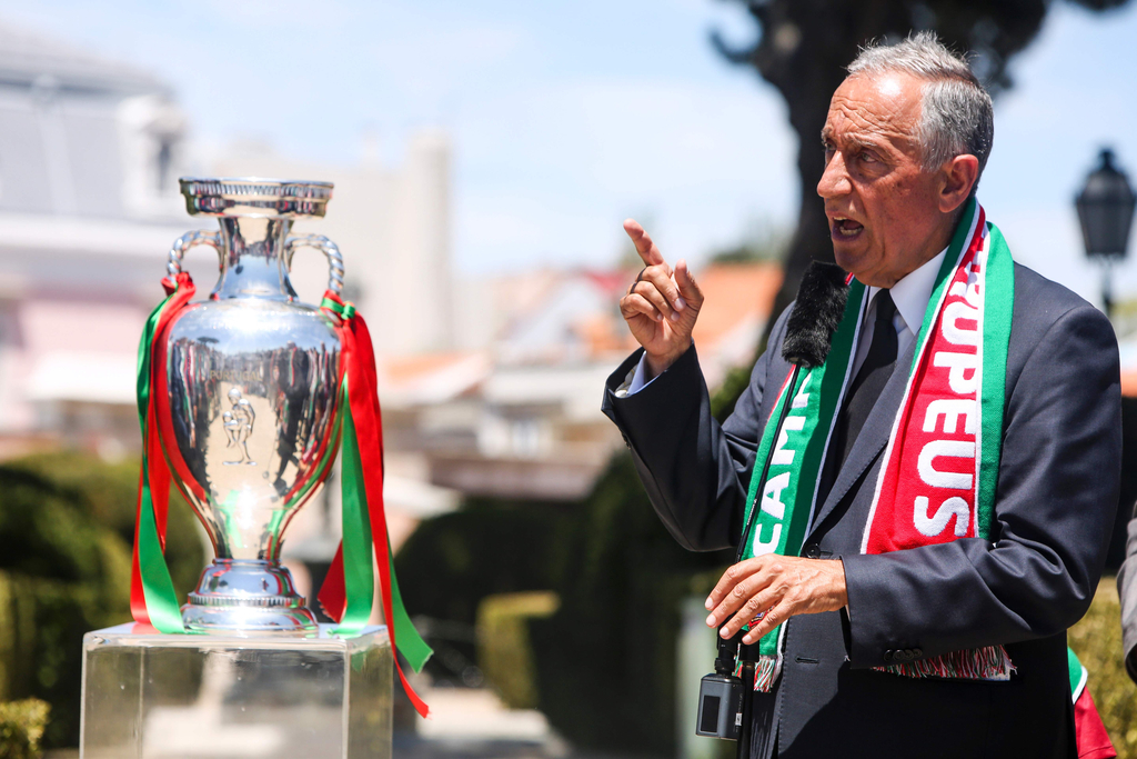 2016年7月11日，葡萄牙里斯本，2016年欧洲杯冠军葡萄牙队回到国内，全体队员和教练乘坐大巴游行并受到葡萄牙总统的接见，全城民众欢欣舞动狂欢庆祝。图为葡萄牙总统与德劳内杯