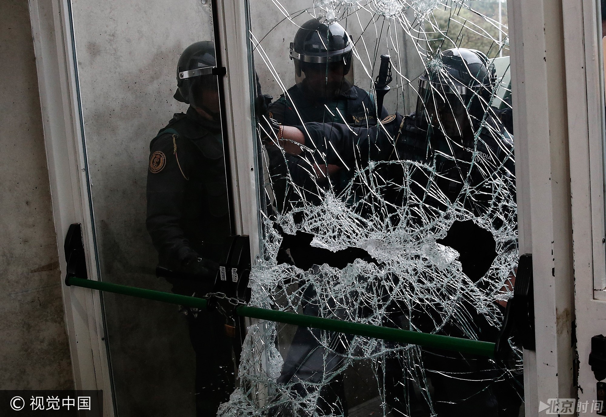 连日来在加泰各地屯重兵的西班牙警方，眼见票站外愈来愈多人聚集，遂派出更多警员戒备，预备清场。在赫罗纳的一个票站，警方以铁锤打碎玻璃窗，当地电视台指警员以警棍驱赶人群，据报无人受伤。图/视觉中国