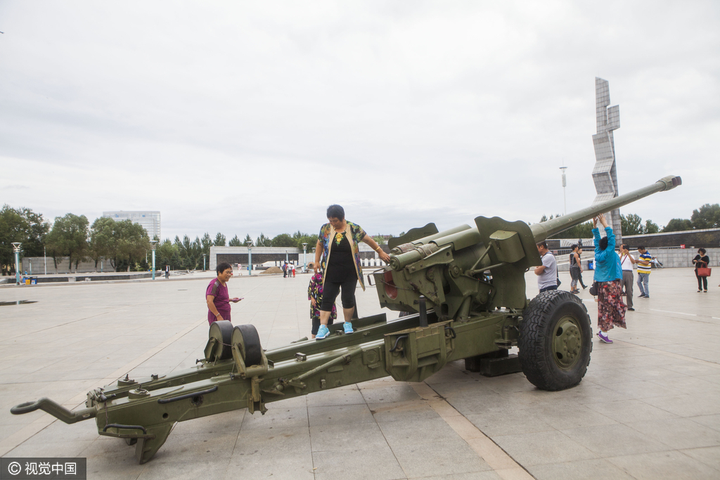 图为市民爬上大炮合影。