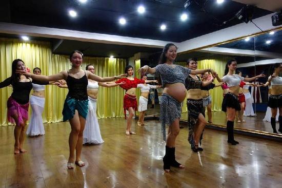 在南岸区的一间舞教室里，一群美女伴随着优美的音乐，跟随着节奏扭动腹部和胯部，跳着肚皮舞。令人吃惊的是，第一排领舞的竟是一位大肚子准妈妈。这位准妈妈不但跳舞，还逐一指导其他舞者，并大声喊着口令：“一、二、三、四……”