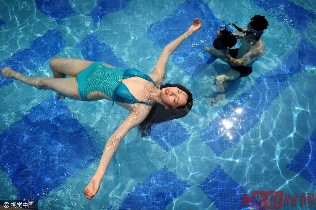 在合肥一个小区的露天泳池里，刘学文正在给郑东妮拍摄水下人像。身材有些消瘦的刘学文挂着一台水下专用相机，不时的潜入水中，按动着快门。而身穿比基尼泳装的郑东妮也配合着刘学文，在水底下摆出一个个唯美的造型。