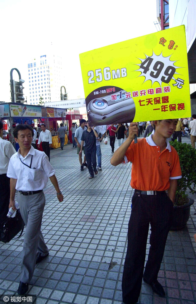 2004年8月31日，北京中关村，销售mp3的柜台摆到了海龙大厦外边，销售人员手举着mp3优惠销售的广告牌招揽顾客，可见当时竞争之激烈。