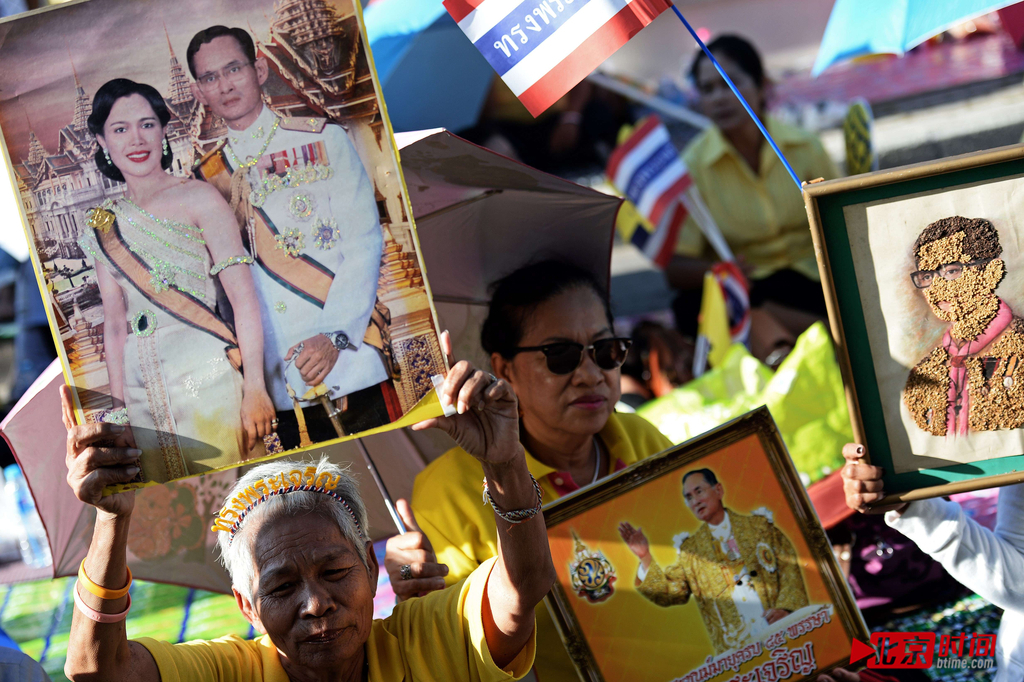 当地时间2014年5月5日，在泰国华欣，国王普密蓬-阿杜德与泰国王储瓦吉拉隆功前往忘忧宫庆祝加冕日。泰国支持者们身穿黄衣手持国王与王后照片在忘忧宫外欢迎。