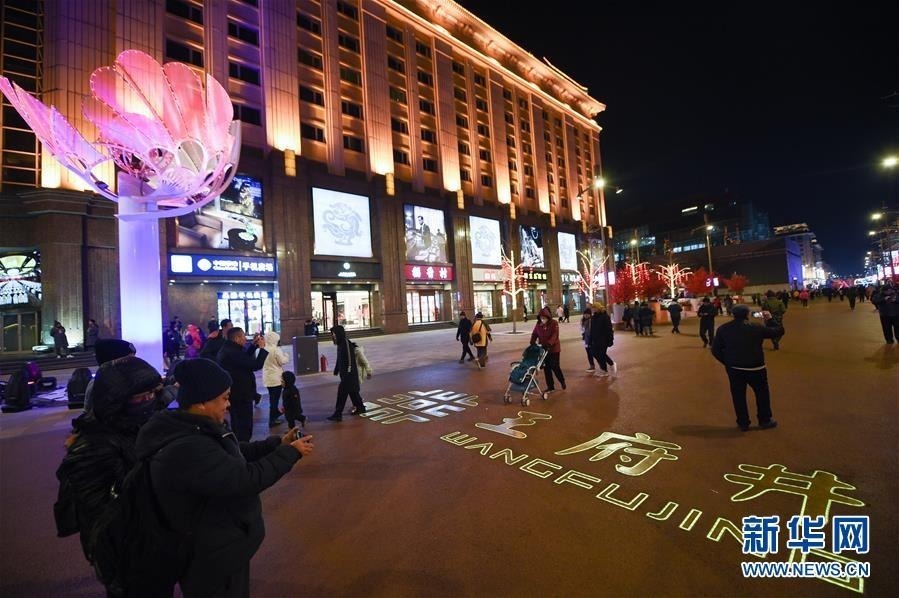 12月20日，市民和游客在新开街的王府井步行街北延段游览。当日，北京王府井步行街北延段正式开街。步行街北延至灯市口大街，长度由548米延长到892米。步行街延长后，王府井街区业态和街区景观将进一步提升。 新华社记者 鞠焕宗 摄
